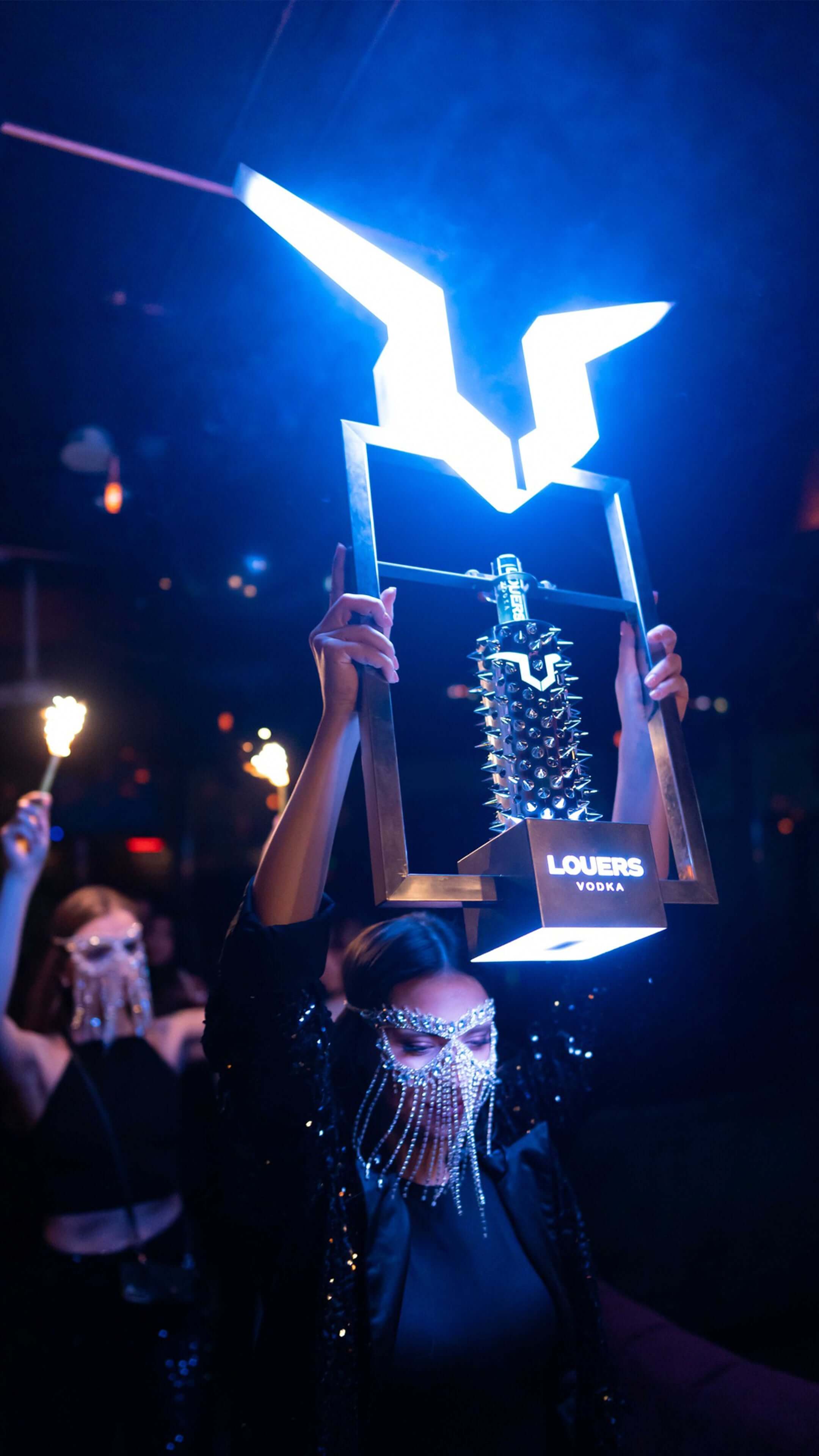 Woman presenting a bottle of LOUERS vodka at high-end nightclub Level27 in Warsaw 