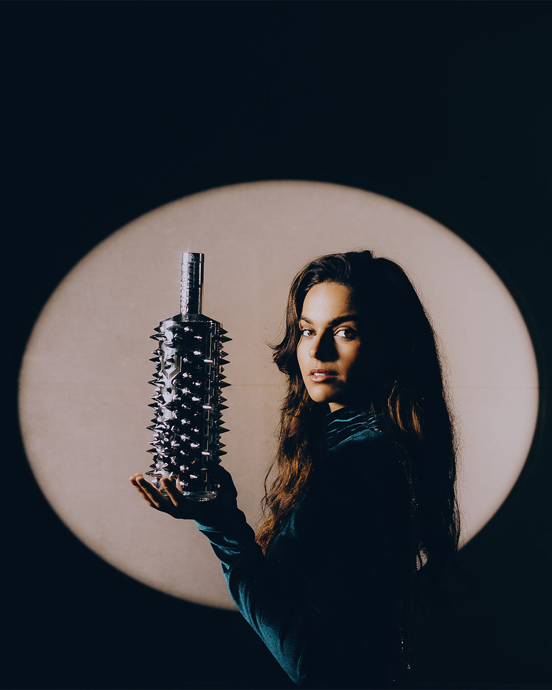 Female model posing with the LOUERS vodka bottle