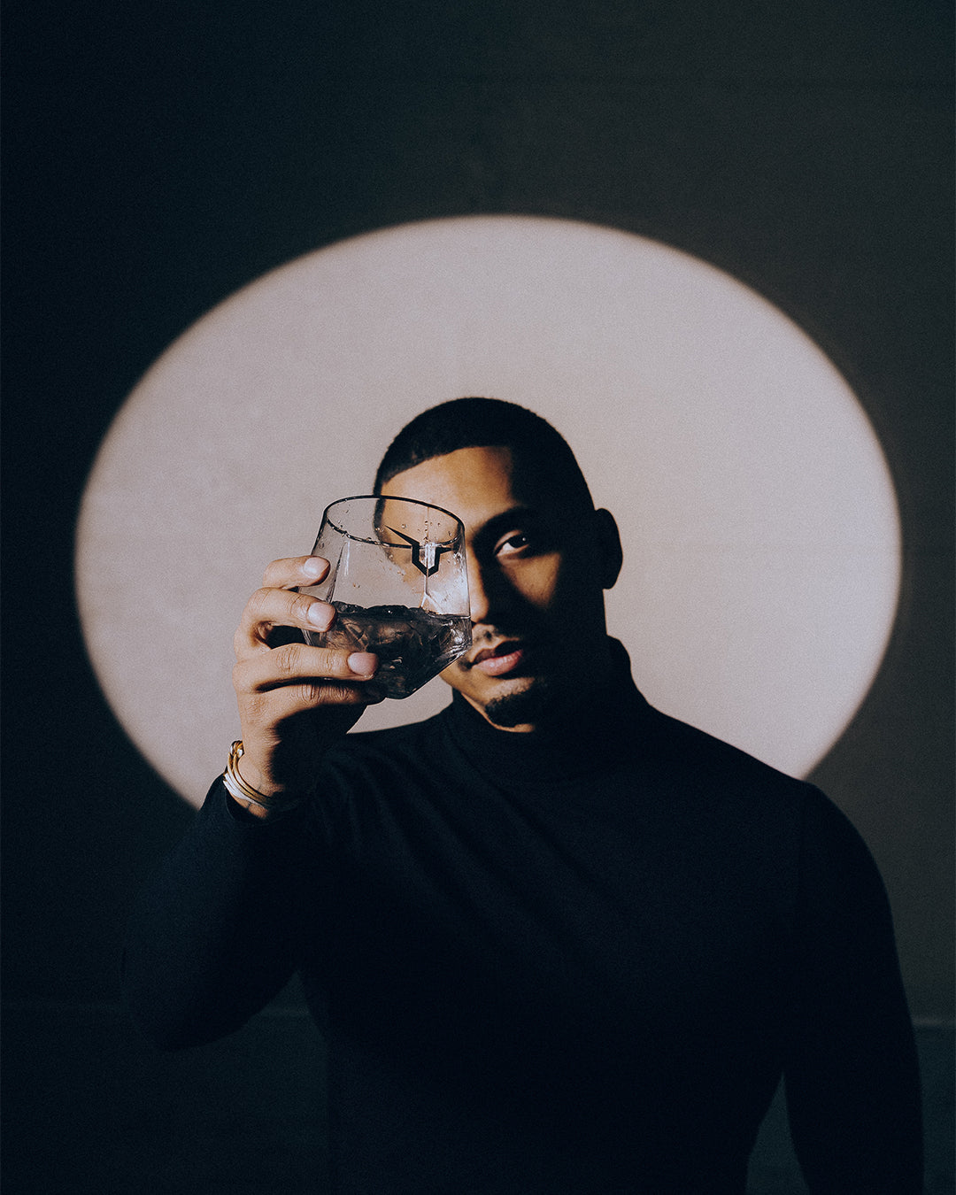 Male model posing with signature LOUERS vodka glassware